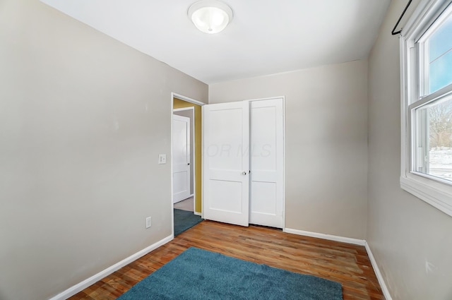 bedroom with multiple windows and hardwood / wood-style floors