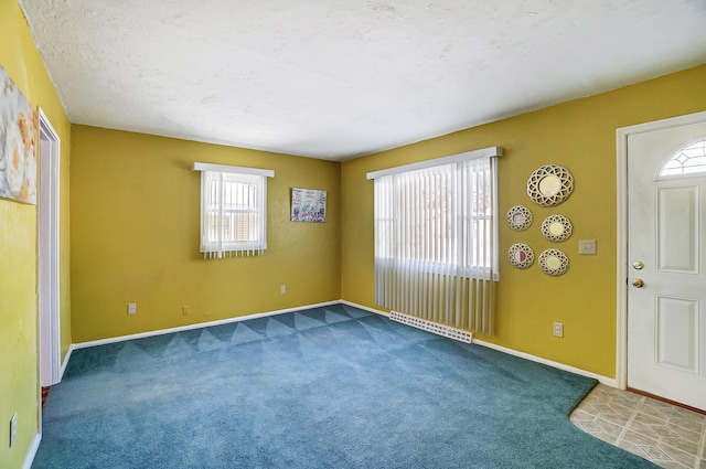 entrance foyer featuring carpet floors and a textured ceiling