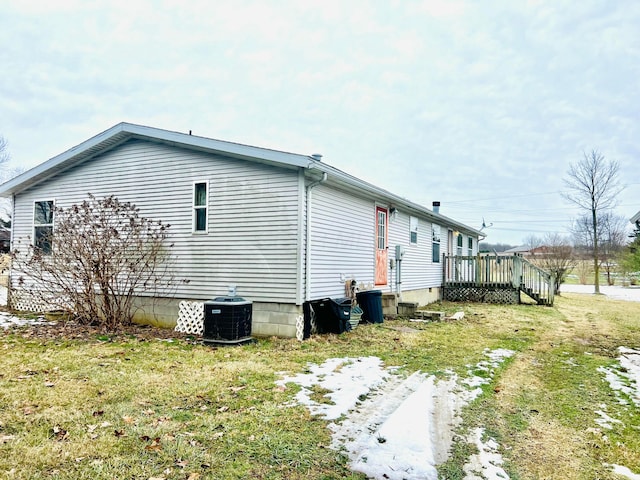 view of home's exterior with a wooden deck, a yard, and central air condition unit