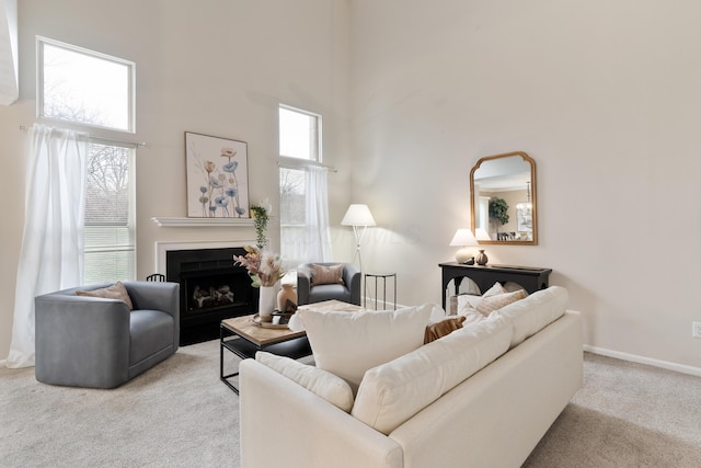 carpeted living room featuring a towering ceiling