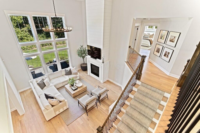 living room featuring an inviting chandelier, light hardwood / wood-style floors, and a high ceiling