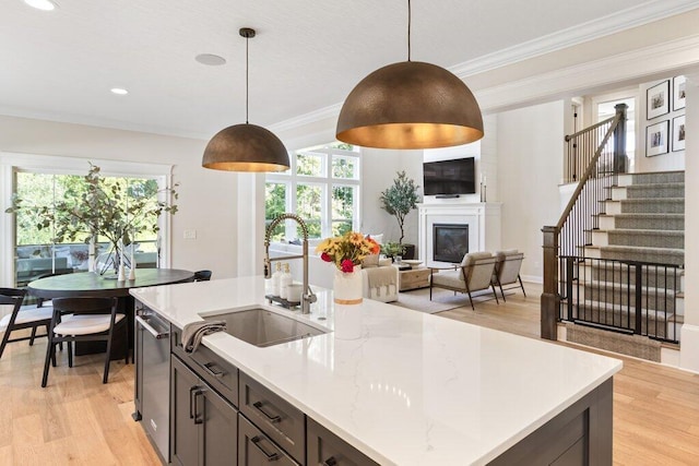 kitchen with pendant lighting, light hardwood / wood-style floors, and sink