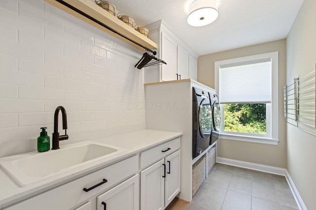 interior space featuring cabinets, separate washer and dryer, sink, and light tile patterned floors