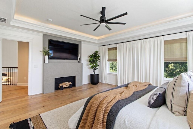 bedroom featuring hardwood / wood-style flooring, a tray ceiling, and crown molding