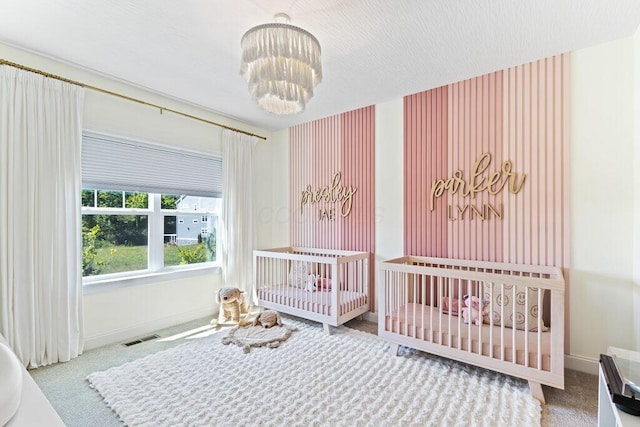 carpeted bedroom featuring a notable chandelier