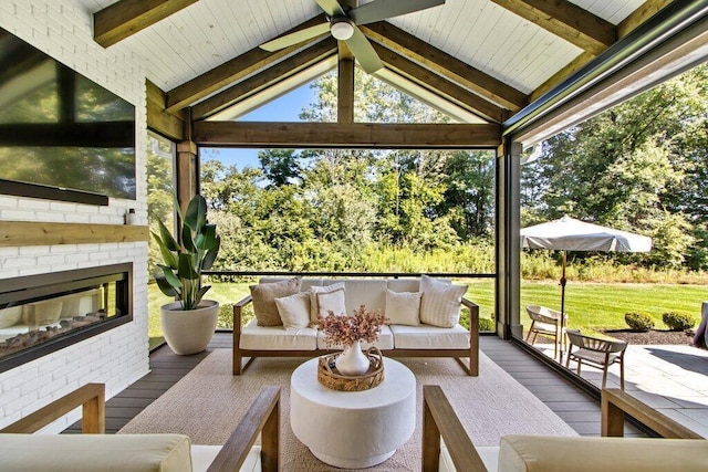 sunroom / solarium with lofted ceiling with beams and a brick fireplace