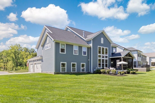 back of house featuring a garage and a lawn