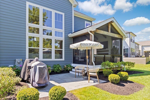 rear view of house featuring a yard, a patio area, and a sunroom