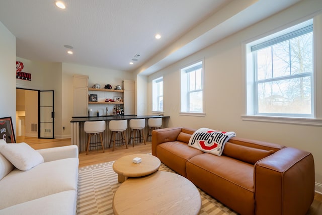 living room with indoor wet bar and light wood-type flooring