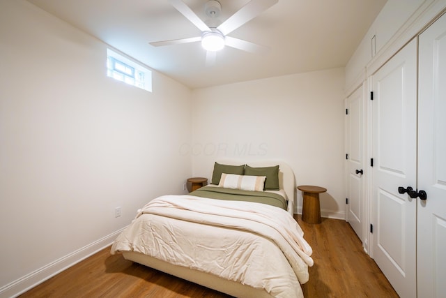 bedroom with hardwood / wood-style flooring, ceiling fan, and a closet