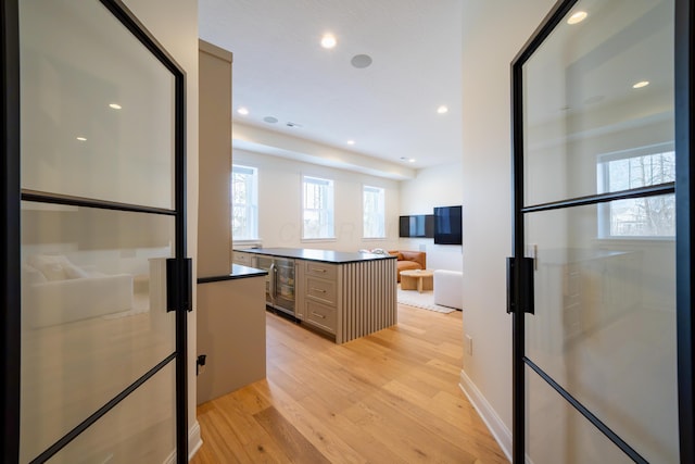 kitchen with wine cooler, light hardwood / wood-style flooring, fridge, and a center island