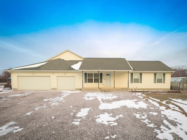 ranch-style home featuring a garage and covered porch