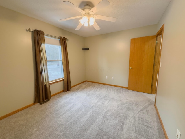 carpeted spare room featuring a textured ceiling and ceiling fan