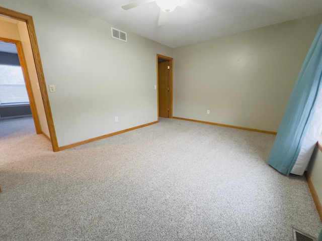 carpeted spare room featuring ceiling fan