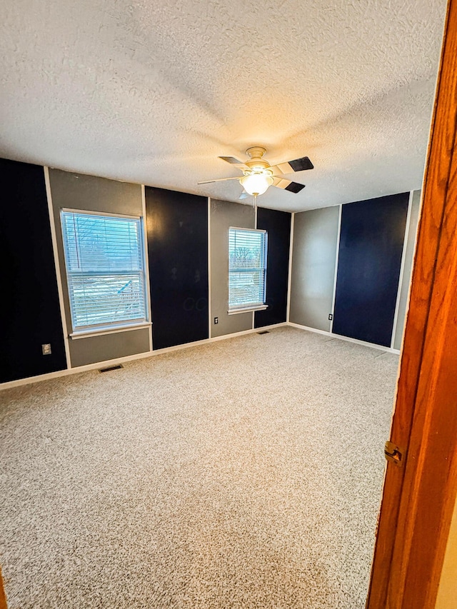 carpeted empty room with a textured ceiling and ceiling fan