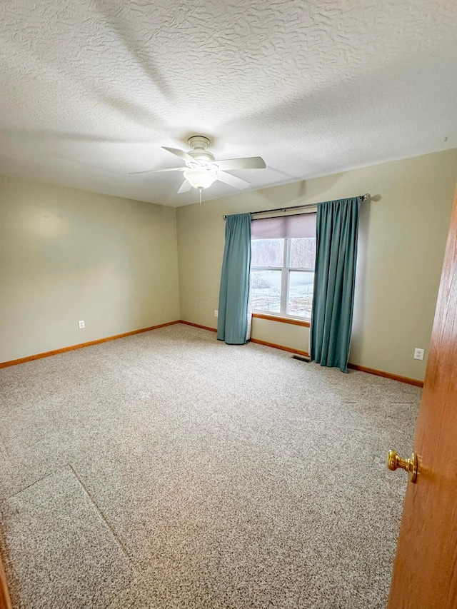 carpeted spare room featuring a textured ceiling and ceiling fan