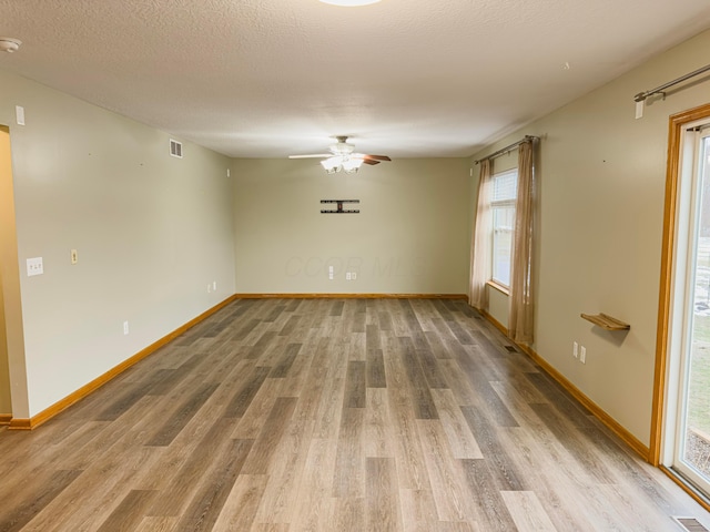 empty room featuring ceiling fan, hardwood / wood-style flooring, and a textured ceiling