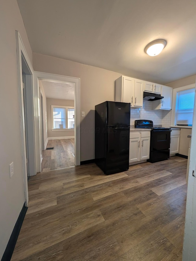 kitchen featuring dark hardwood / wood-style flooring, white cabinets, backsplash, and black appliances