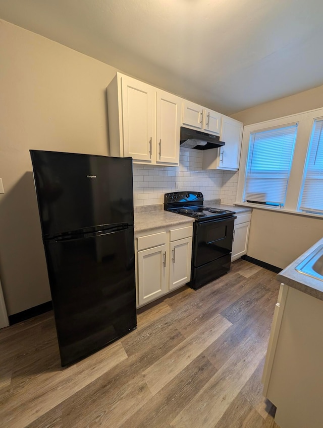 kitchen with sink, tasteful backsplash, black appliances, light hardwood / wood-style flooring, and white cabinets