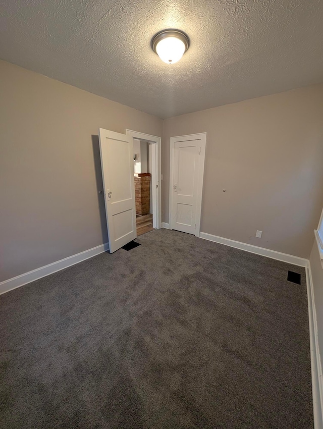 carpeted spare room with a textured ceiling