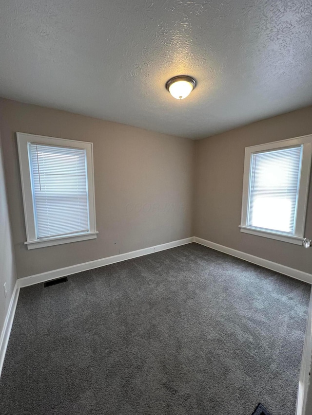 carpeted spare room featuring a textured ceiling