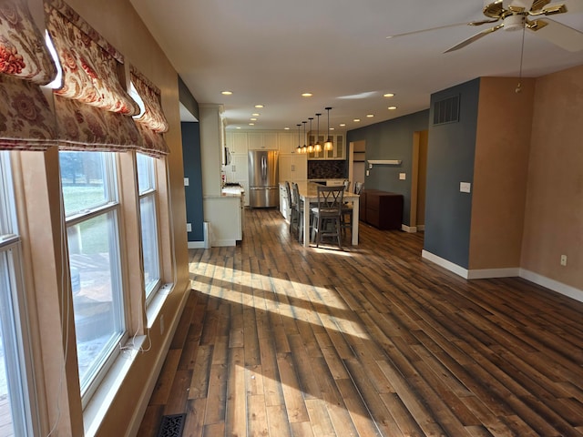 unfurnished living room featuring ceiling fan and dark hardwood / wood-style flooring