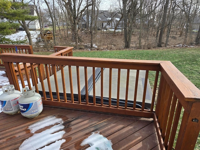 wooden deck featuring a lawn