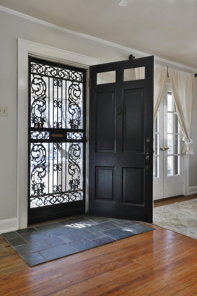 entrance foyer featuring dark wood-type flooring and ornamental molding