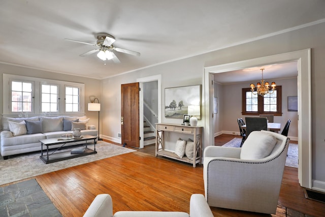 living room featuring crown molding, ceiling fan with notable chandelier, and hardwood / wood-style floors