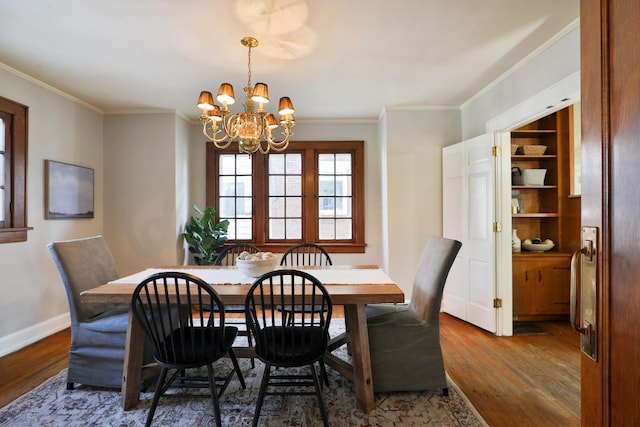 dining space featuring crown molding, dark hardwood / wood-style floors, and an inviting chandelier