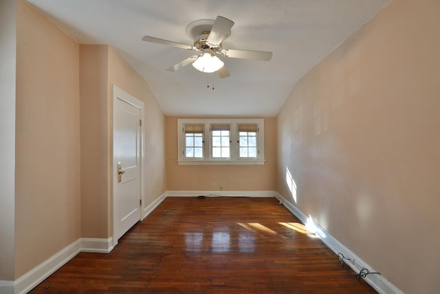 unfurnished room featuring ceiling fan, dark hardwood / wood-style flooring, and vaulted ceiling