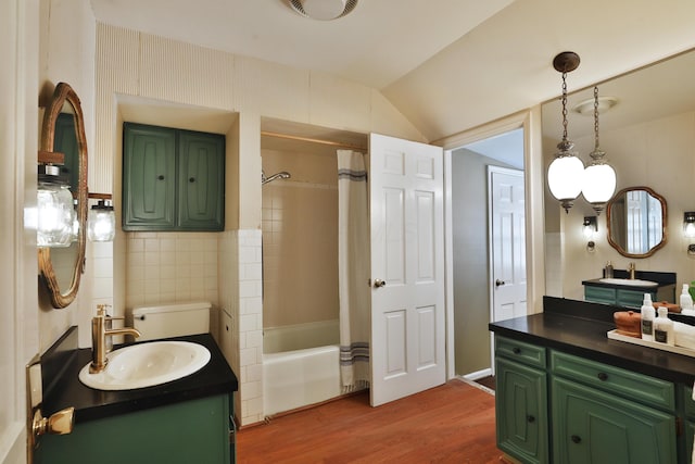 bathroom featuring vaulted ceiling, tile walls, vanity, shower / bath combo, and hardwood / wood-style flooring