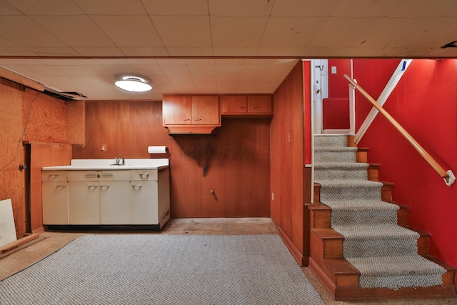 kitchen featuring wooden walls and light carpet