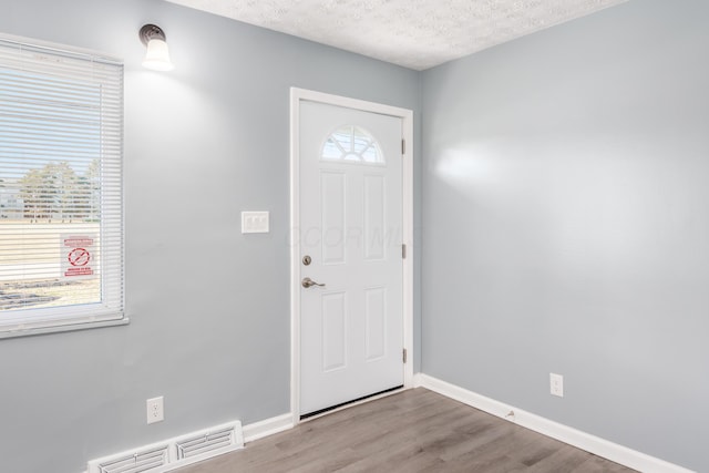 foyer featuring hardwood / wood-style flooring and a textured ceiling