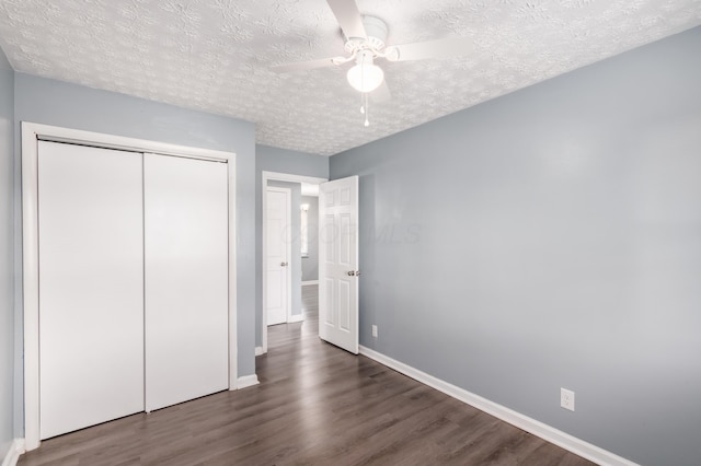 unfurnished bedroom featuring dark hardwood / wood-style flooring, ceiling fan, a closet, and a textured ceiling