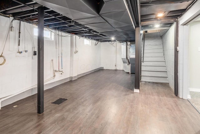 basement with hardwood / wood-style flooring and heating unit