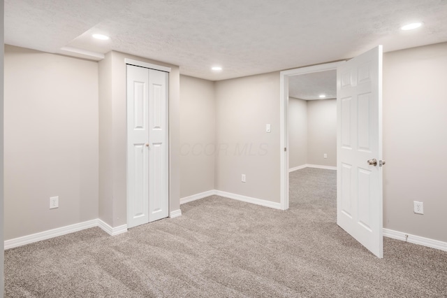 basement featuring carpet floors and a textured ceiling