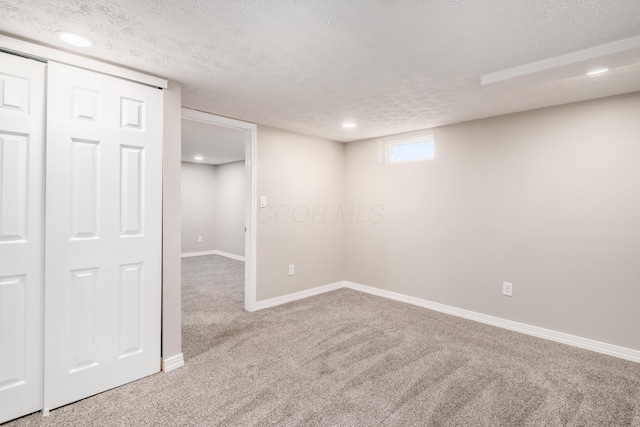 basement with carpet flooring and a textured ceiling