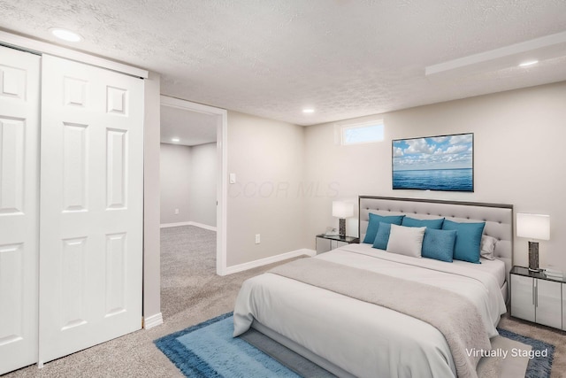 bedroom with light carpet and a textured ceiling