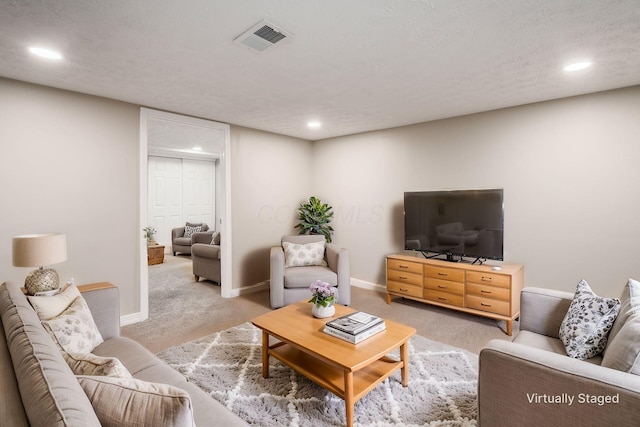 living room featuring light carpet and a textured ceiling