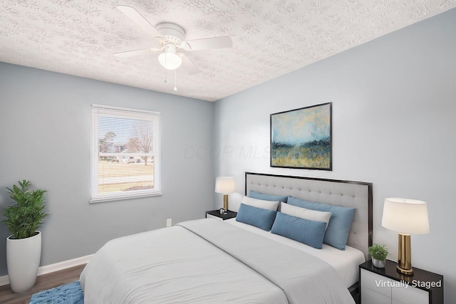 bedroom featuring hardwood / wood-style floors, a textured ceiling, and ceiling fan