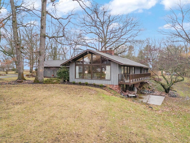 exterior space featuring a wooden deck and a lawn