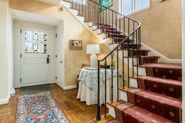 foyer featuring parquet floors and a towering ceiling