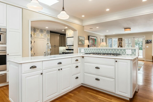 kitchen with white cabinetry, pendant lighting, sink, and a kitchen island