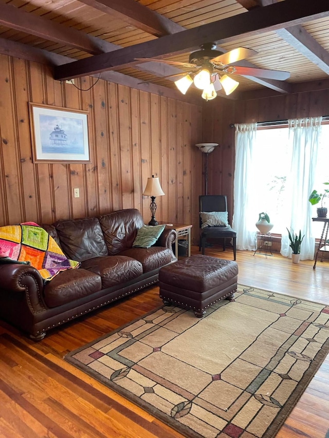 living room with beamed ceiling, hardwood / wood-style floors, and wood walls