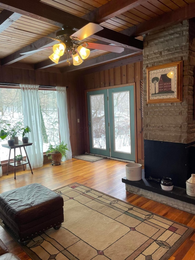 living room with wood ceiling, beam ceiling, wood-type flooring, and wood walls