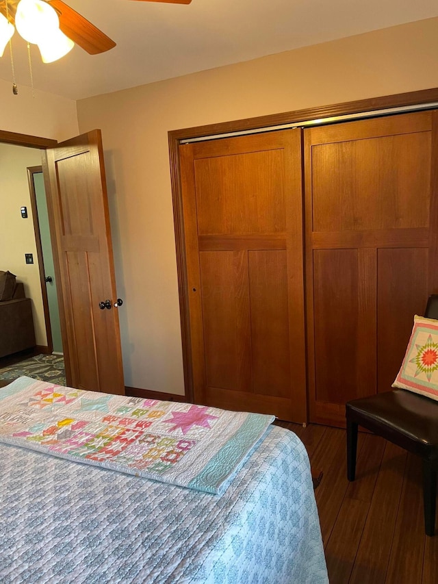 bedroom featuring ceiling fan, dark hardwood / wood-style flooring, and a closet