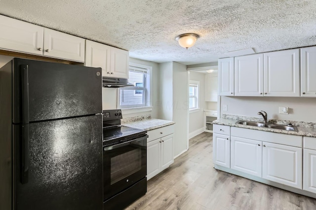 kitchen featuring sink, white cabinetry, a textured ceiling, light wood-type flooring, and black appliances