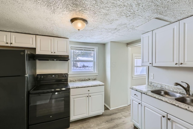 kitchen featuring sink, white cabinetry, a wealth of natural light, black appliances, and light hardwood / wood-style floors