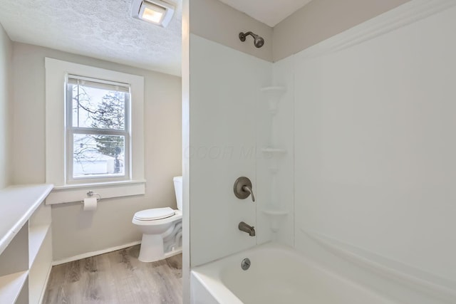 bathroom featuring shower / tub combination, toilet, hardwood / wood-style floors, and a textured ceiling